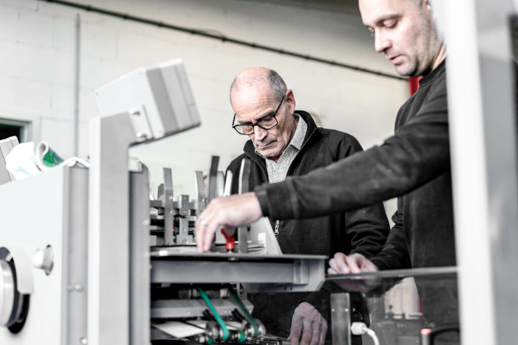 Zwei Mitarbeiter der Firma Hartmann Druck in Hilzingen beim bedienen einer Maschine.